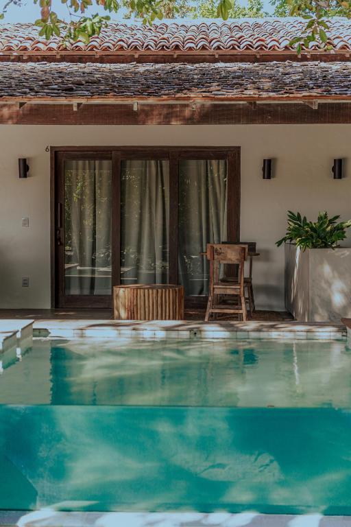 Vue aérienne de l'Anacardier Privé Hotel et sa piscine scintillante entourée de palmiers